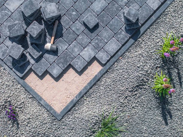 Aerial view of a stone patio featuring a hammer and a shovel placed on the surface, showcasing outdoor tools and materials for seasonal concrete maintenance in Atlanta, GA.