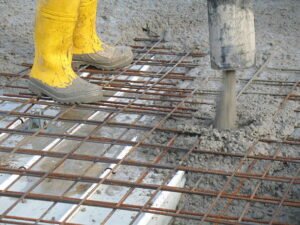 Construction workers pouring concrete for a house concrete foundation during residential building construction.