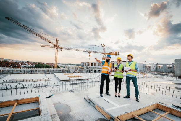 Three construction workers standing together on a busy construction site in Metro Atlanta, specializing in custom concrete work.