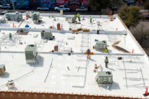A roof under maintenance with construction workers performing repairs.