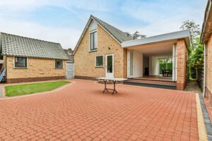 A beautiful home featuring a large front porch with elegant stamped concrete flooring. 