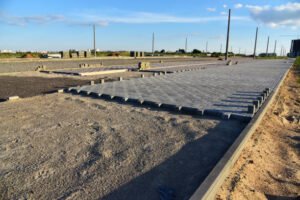 A concrete walkway is under construction on a road, indicating ongoing commercial driveway paving work.