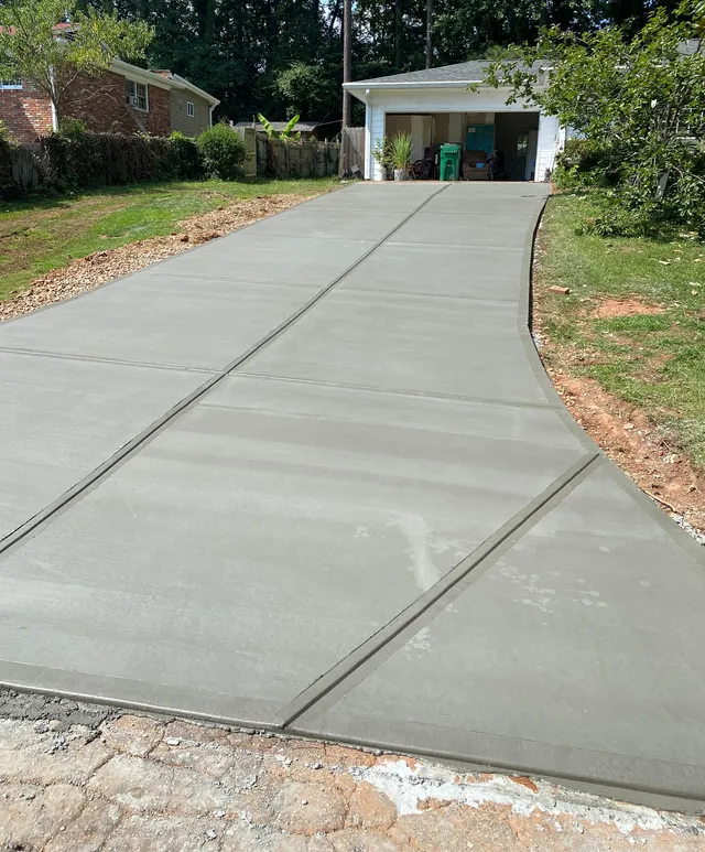 This picture shows a driveway to a home garage with newly done concrete work.
